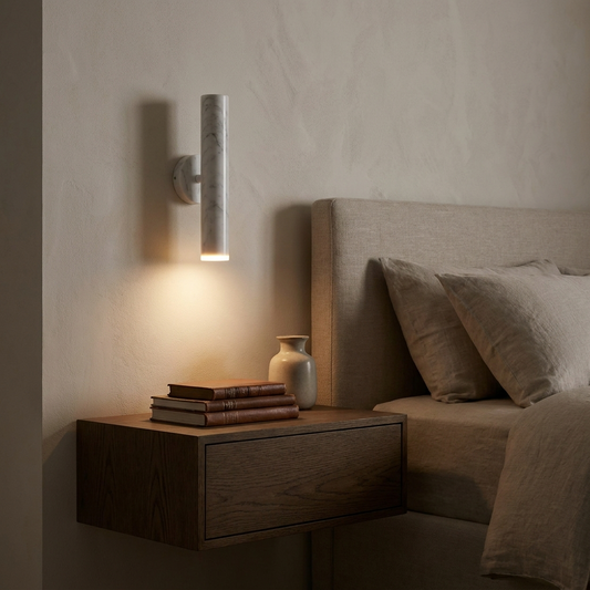 Slim marble-finish wall sconce mounted above a bedroom nightstand